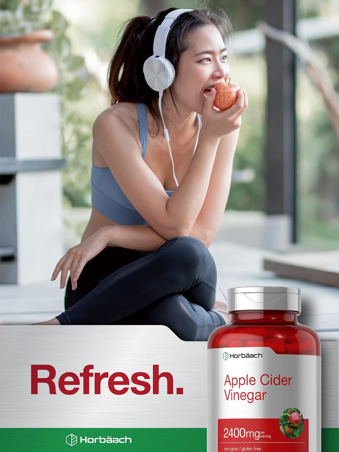 Woman eating an apple with a bottle of Herb Bach Apple Cider Vinegar in the foreground.