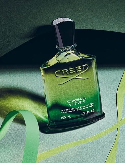 Creed Original Vetiver perfume bottle on a green background