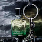 Creed Original Vetiver perfume bottle with keychain and belt on a dark background