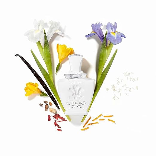 Creed perfume bottle with flowers and vanilla bean on a white background
