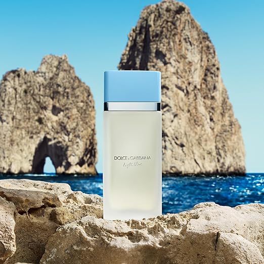 Dolce & Gabbana perfume bottle on rocks with ocean and cliffs in the background