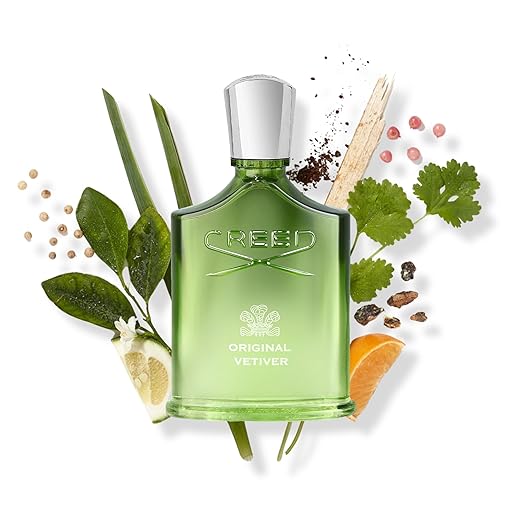 Green Creed perfume bottle with leaves and spices on a white background
