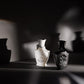 Two Creed perfume bottles on a dark surface with soft focus background